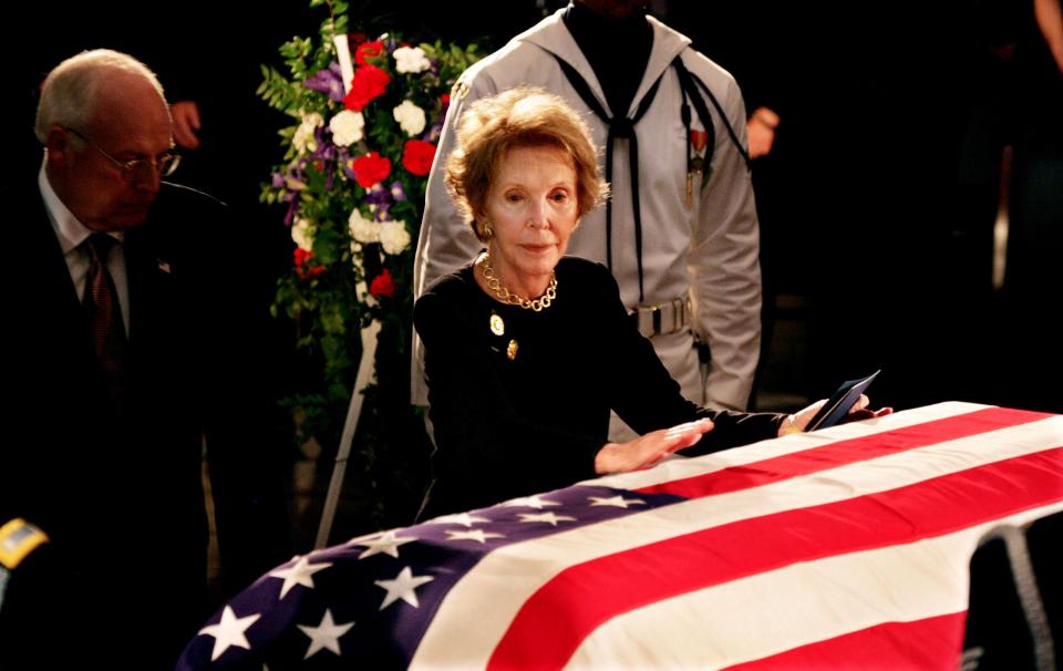  Former first lady Nancy Reagan, with Vice President Dick Cheney behind her, touches the casket of her husband, Ronald Reagan as he lies in state inside the Rotunda of the U.S. Capitol