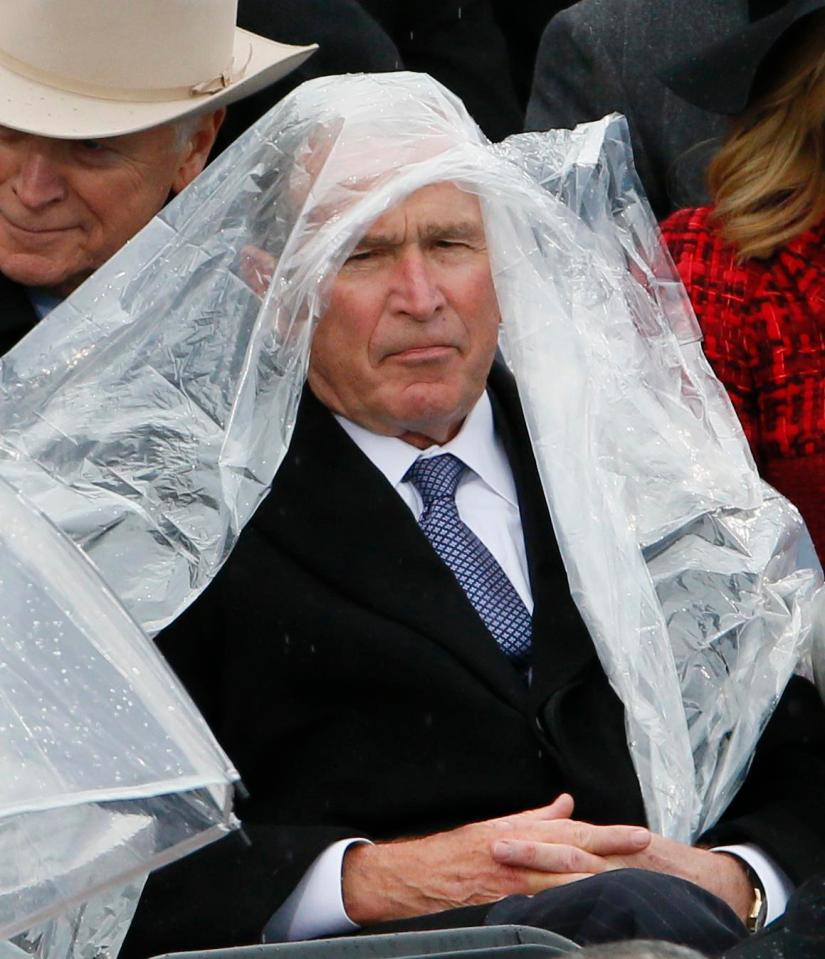  Former President George W. Bush keeps covered under the rain during the inauguration ceremony as Trump is sworn in