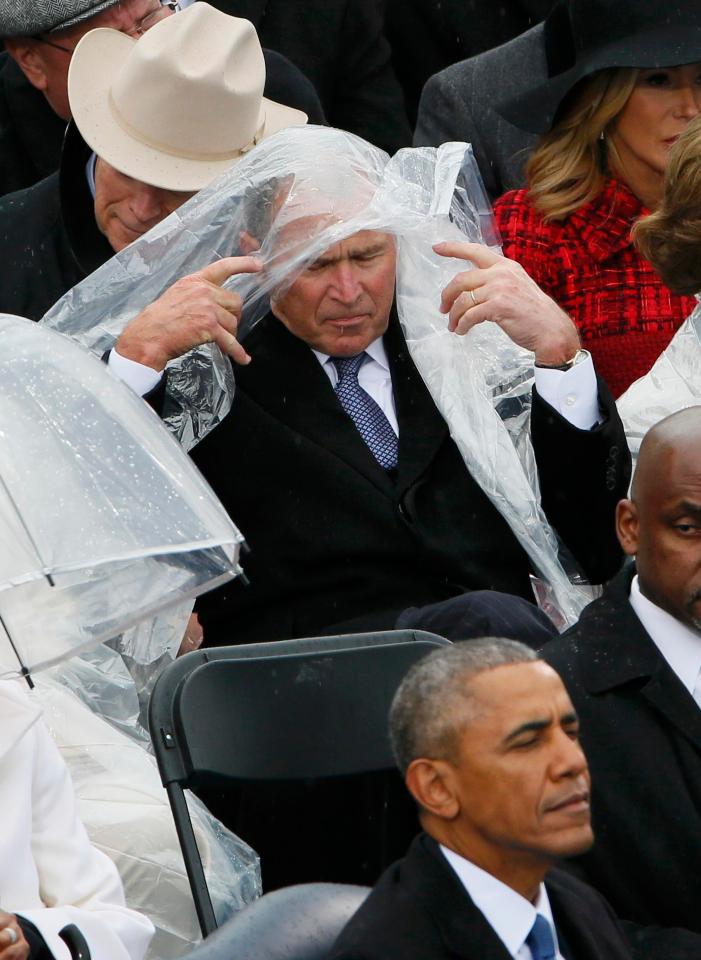  ...but the wind proved to be a problem for the former president as he kept trying to push the poncho out of his face