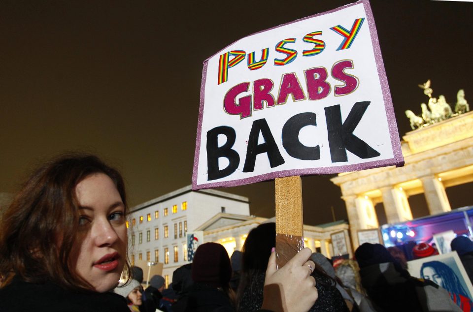  A protester in Berlin holds a placard saying 'Pussy grabs back' in reference to the leaked tape in which Trump boasts of grabbing a woman by the pussy