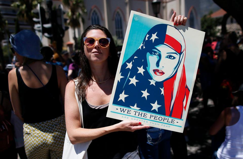  'We the people' sign is held in South Africa as it joins 30 countries holding protests against Trump's Presidency