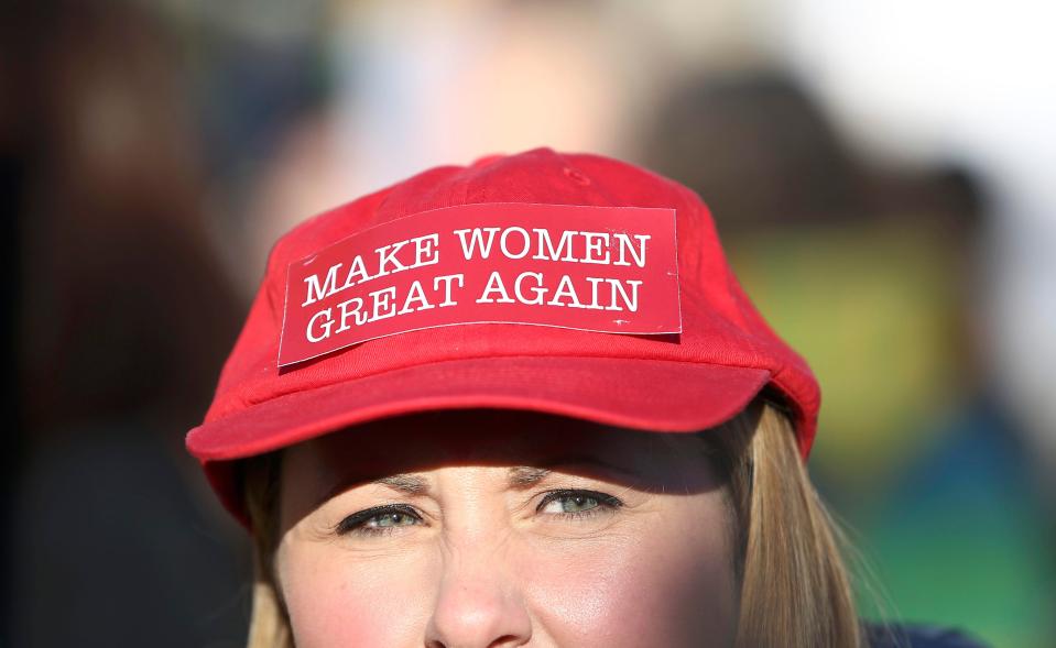  Woman wears protest hat on the march, which says: Make women great again