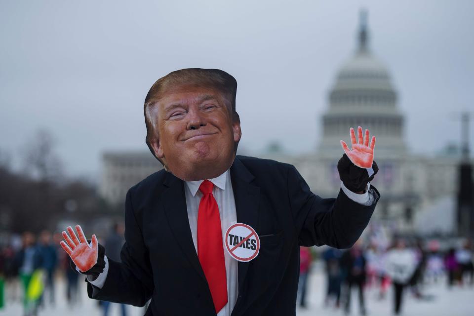  Over in America, one demonstrator wears a mask of the US President dancing while walking past the Capitol