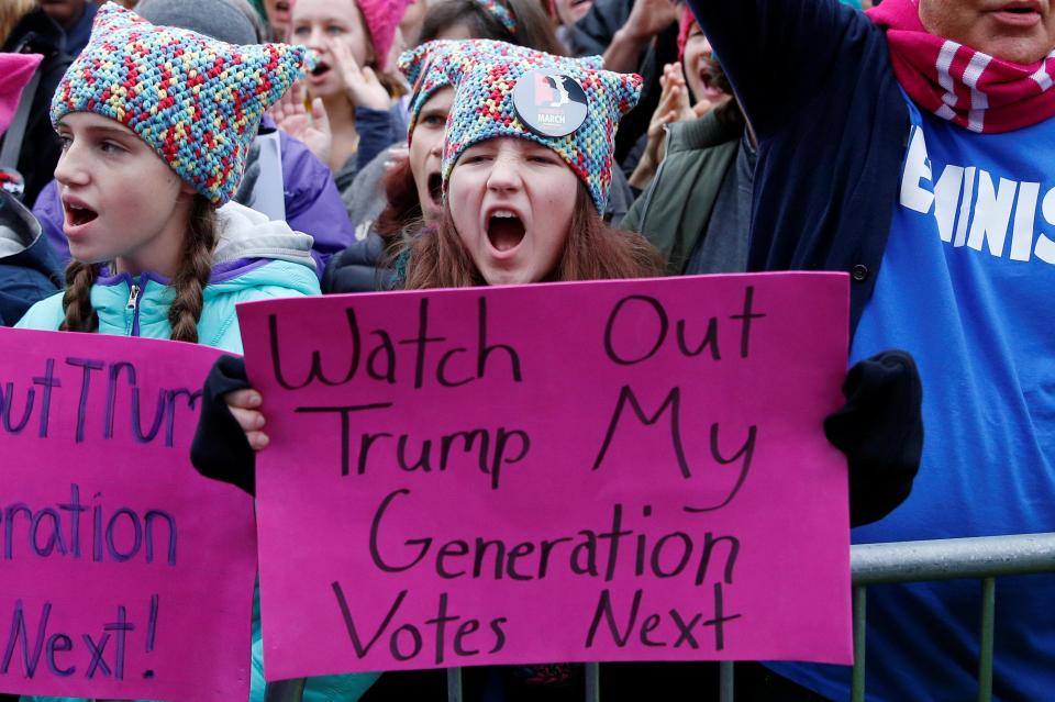  A young protester is seen with a warning sign for the new President