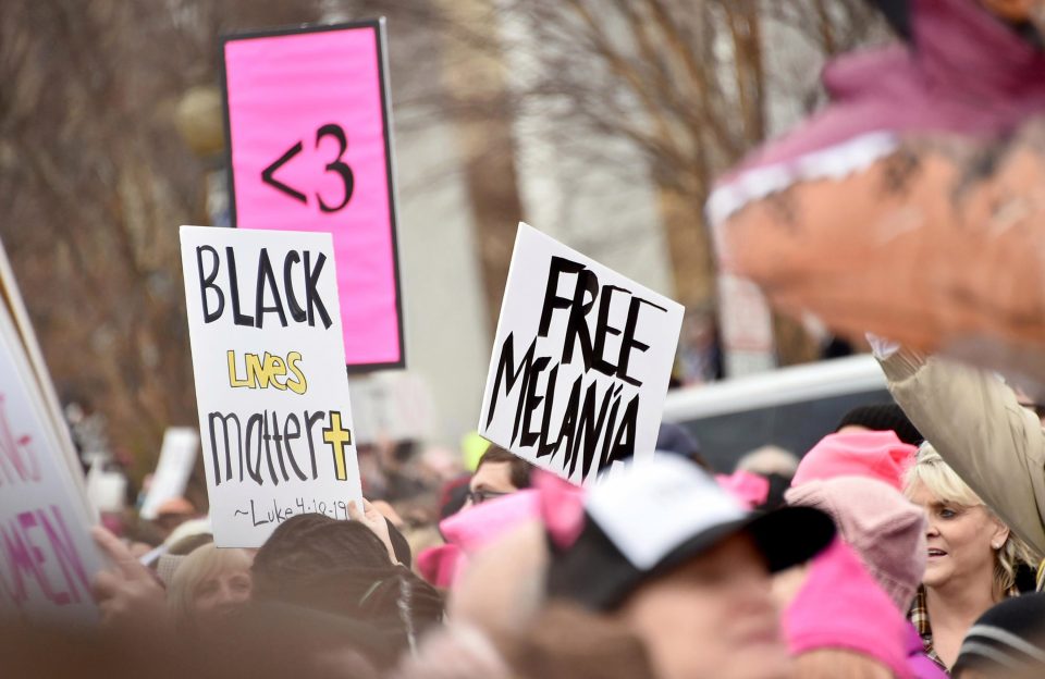  A protester brandishes a sign sporting the slogan 'Free Melania'