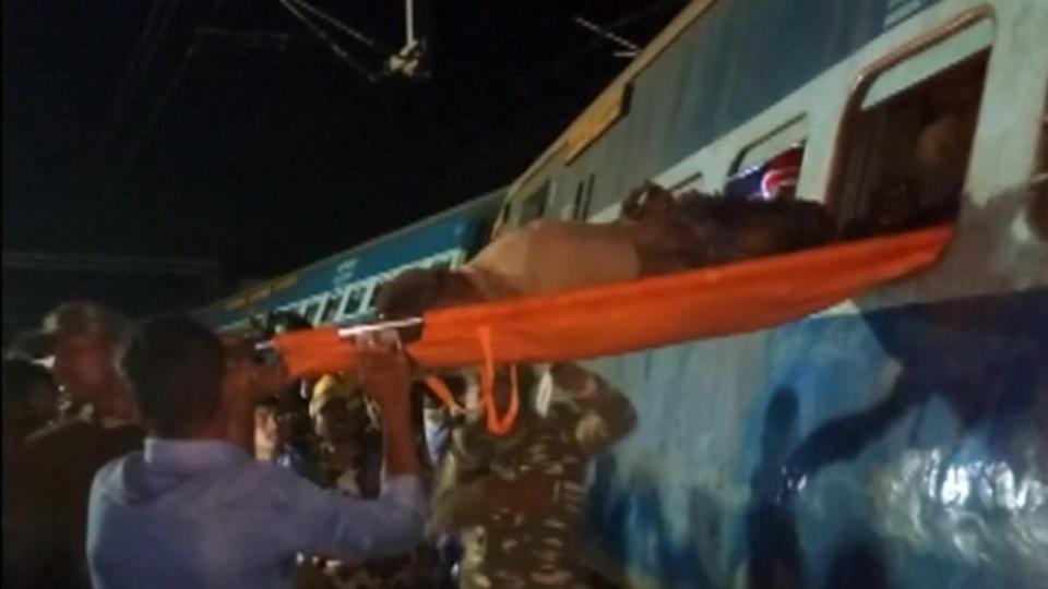  One dust-covered passenger is lifted through a window on a stretcher by emergency workers