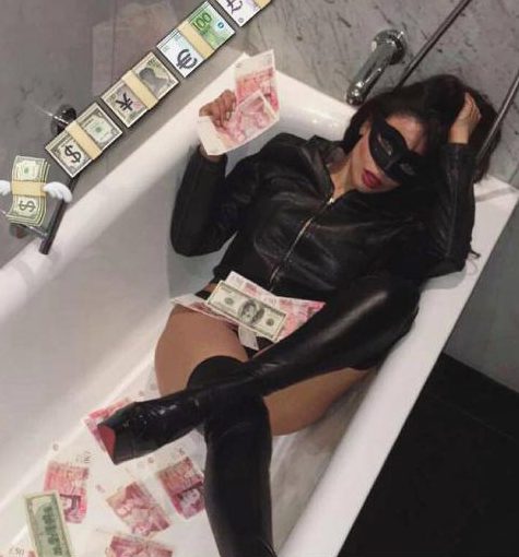  Samantha, pictured in a bath while wearing thigh-high boots, said she tones down her look for work and often goes make-up free