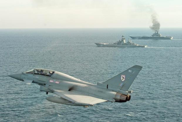 A Royal Air Force Typhoon shadowing Russian Warships Petr Velikiy (centre) and the Admiral Kuznetsov (background) in the North Sea