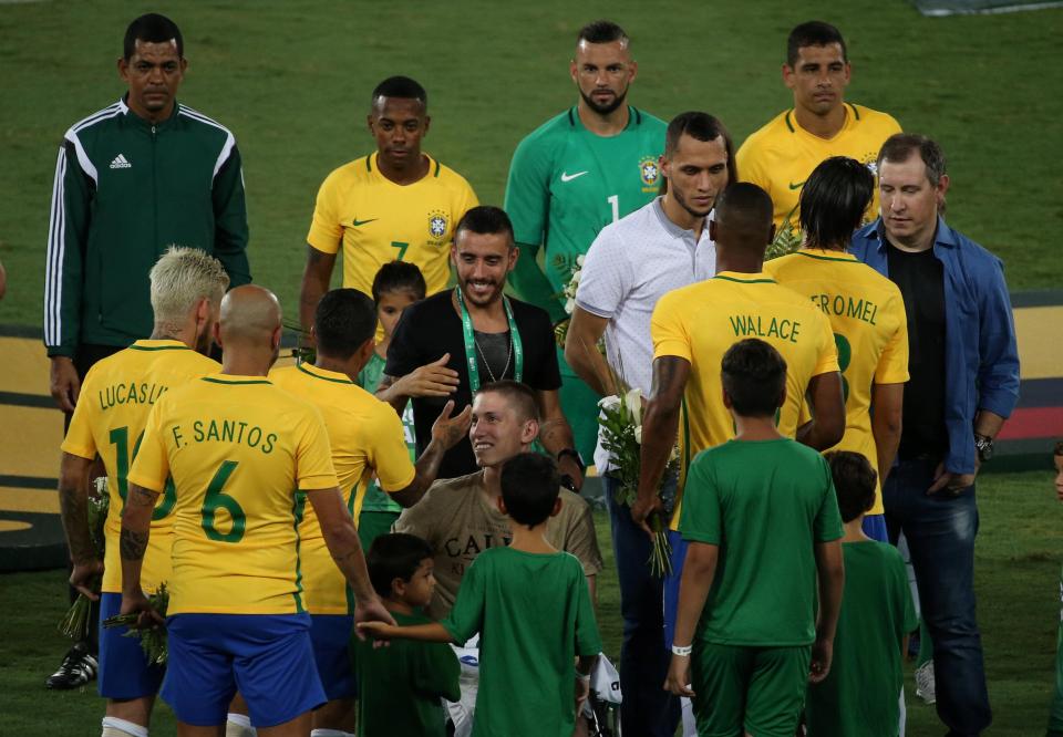  The Brazil players greet the survivors on the plane crash before their match with Colombia