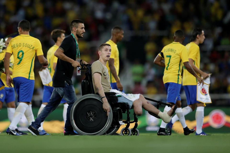  Alan Ruschel helps Jackson Follmann off the field before kick-off in Rio