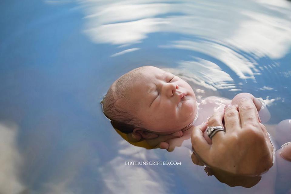  The peaceful moment a newborn baby rests in calm water in their mother's hands