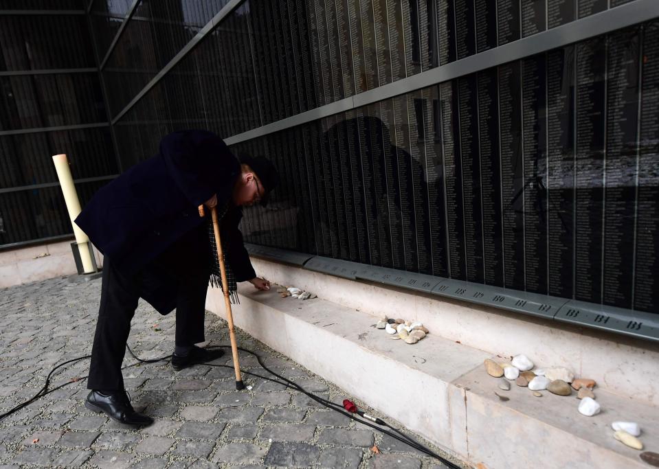  A Jewish man prepares his memorial stone in front of a black marble wall with hundred-thousands Hungarian victims' names at the local synagogue of Central Europe's first Holocaust museum in Budapest earlier today