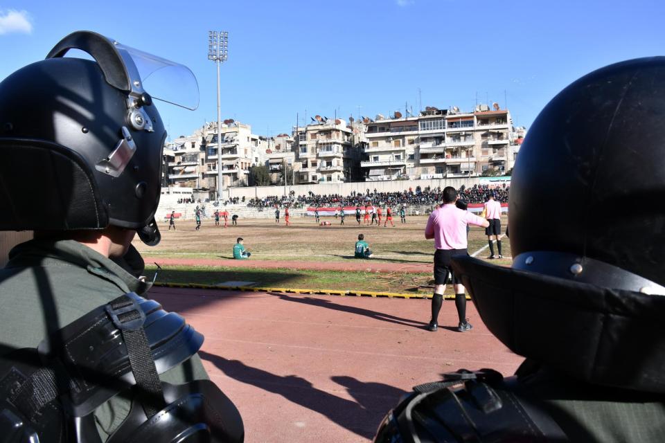  Riot police watch the first football game in the city for years