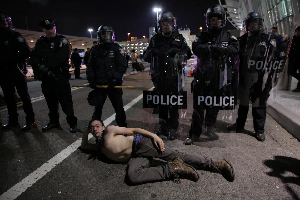  Protesters gather outside Terminal 4 at JFK airport in opposition to the ban