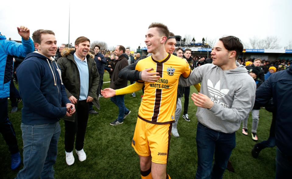  Sutton United's triumphant players are mobbed by jubilant fans as they exit the pitch