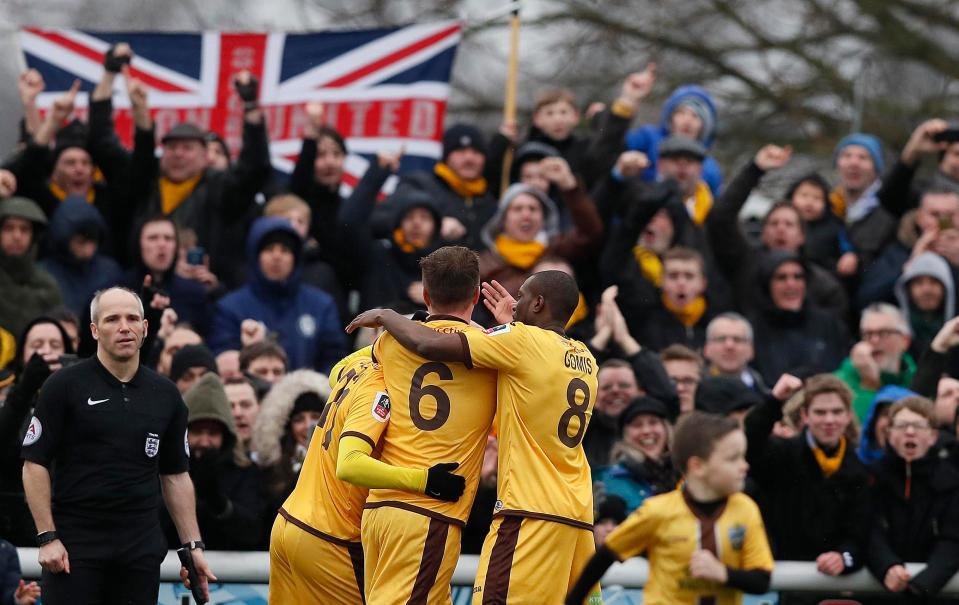  Jamie Collins is mobbed by his team-mates after netting the crucial goal to dump Leeds out of the cup