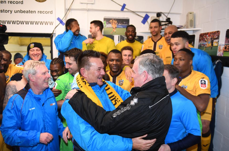  Sutton boss Paul Doswell celebrates victory with his chairman Bruce Elliot in front of their triumphant squad