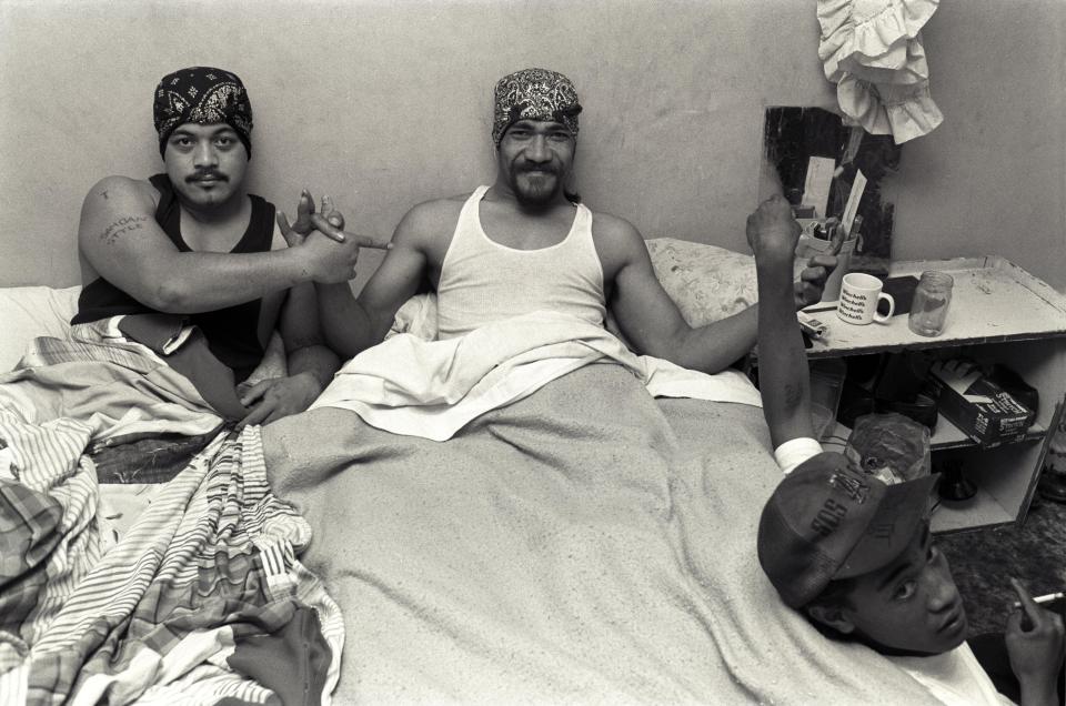  The leader of the Sons of Samoa - a gang the Crips have teamed up with - poses in bed after being paralysed from the waist down in a shooting