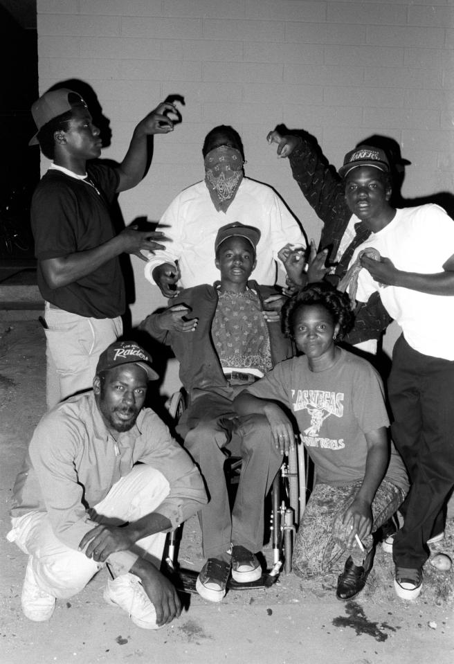  Members of the street gang pose for a picture with a wheelchair-bound friend