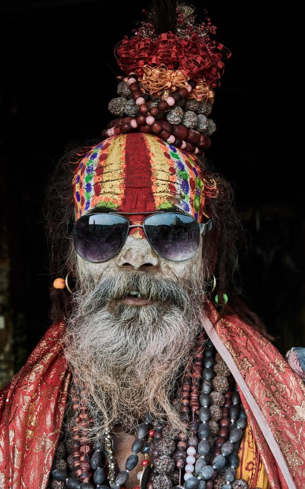  A holy dude with a decorative face and headdress wearing sunglasses, taken in Kathmandu, Nepal