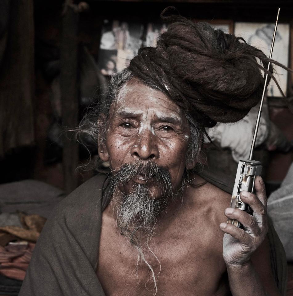  This holyman has a radio where he can hear the society he has given up