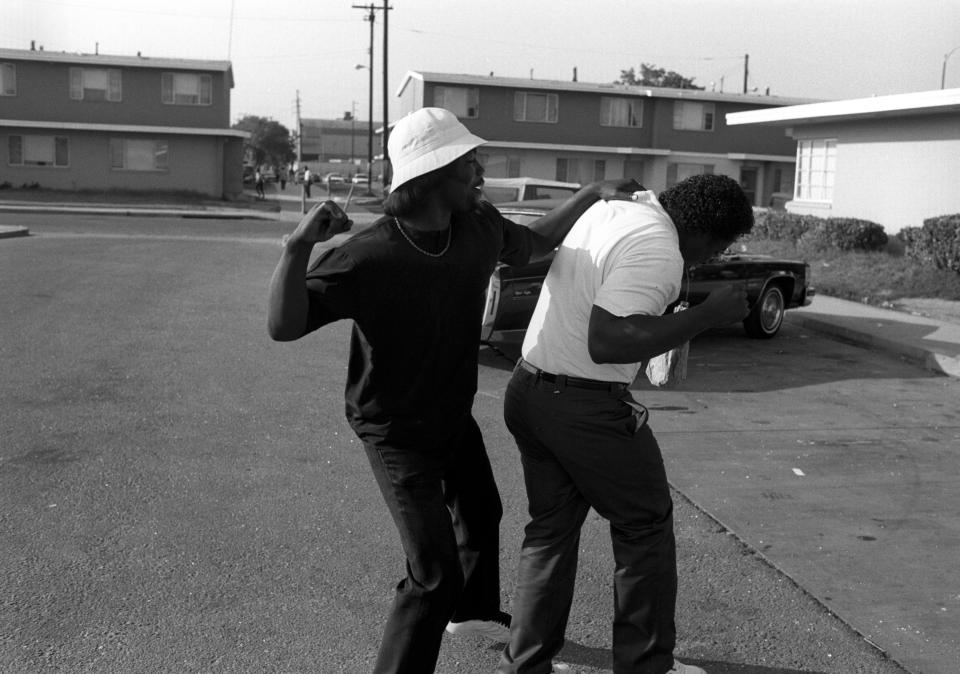  Two members of the gang grapple in a playful fight on the street