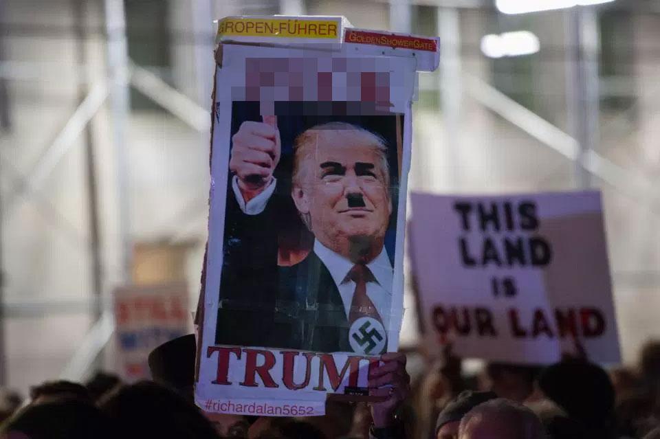  Protesters hold up signs at the New York rally