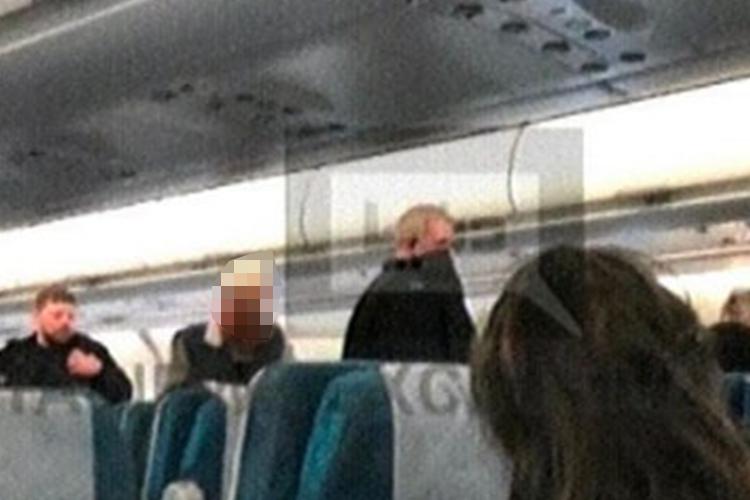  A picture from onboard the plane shows cops walking through the aisle