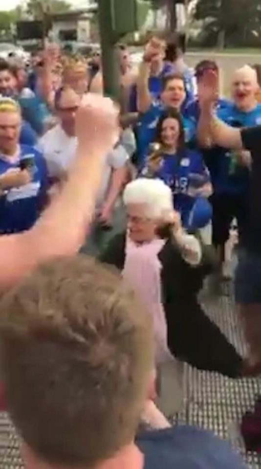  Leicester fans dance with an elderly woman in Seville