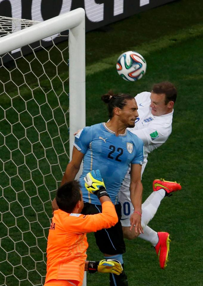  68-cap Caceres heads clear of Wayne Rooney in a World Cup clash