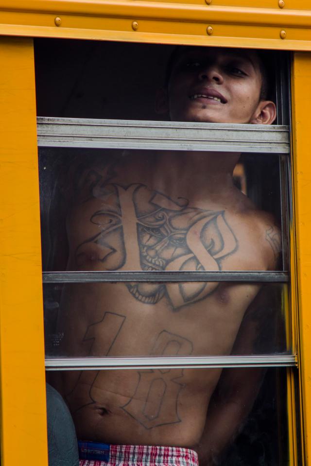  The number 18 is inked in large figures or roman numerals across the chests of many convicted crooks such as this man being transferred between jails in El Salvador last year