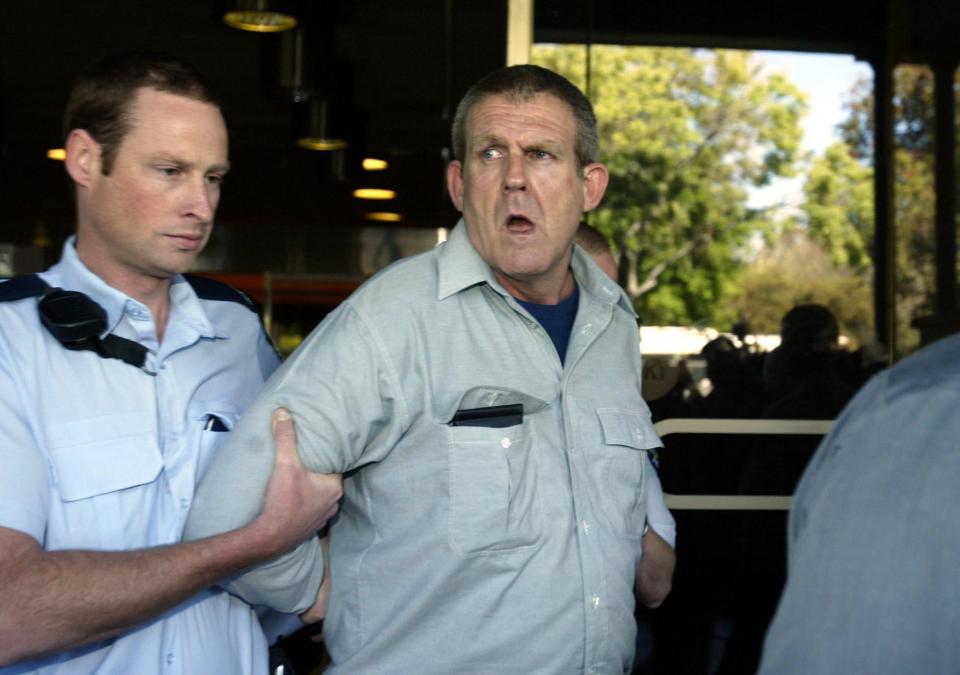  Murdoch is led away by a policeman, outside the Adelaide Supreme Court