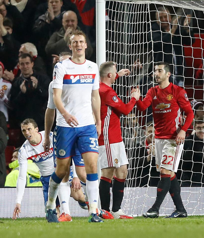  Mkhitaryan is congratulated by Wayne Rooney after his goal against Wigan last week in the FA Cup