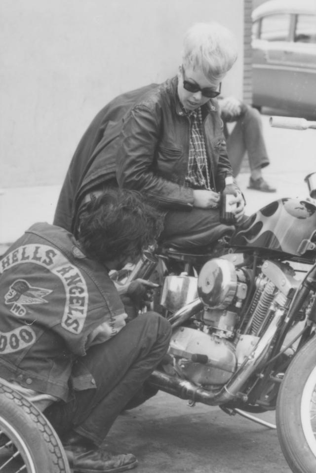  A biker tinkers with his beloved Harley as his old lady watches