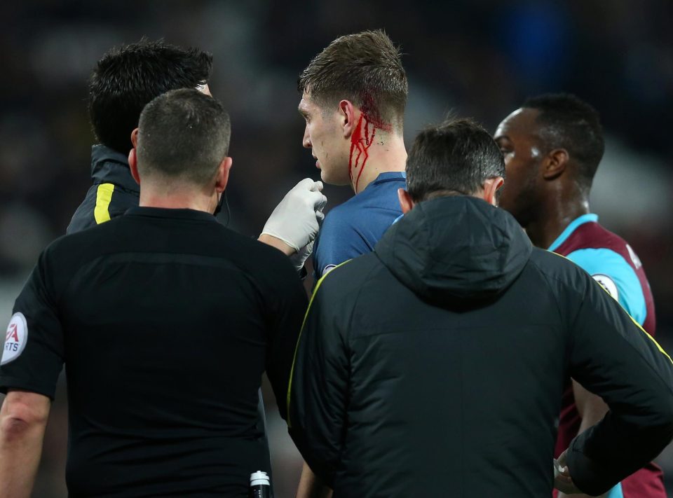  John Stones receives treatment for a cut after he was caught by the studs of Winston Reid