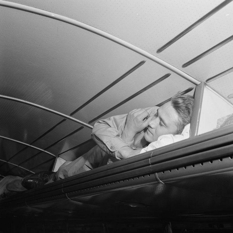  A passenger takes a sneaky nap on a luggage shelf