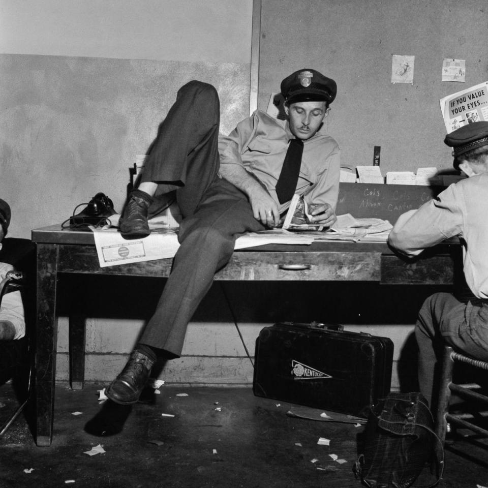  A guard takes a break from work, while reading a local newspaper