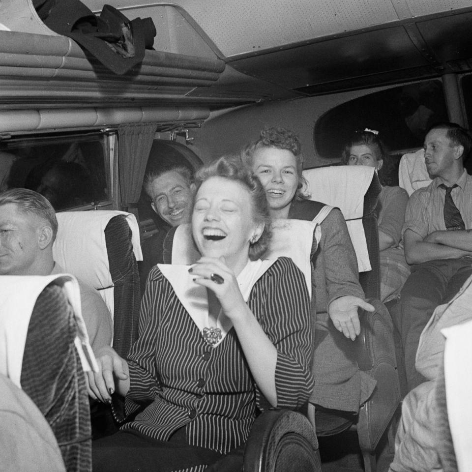  A group of young men and women share a giggle in the back of the bus