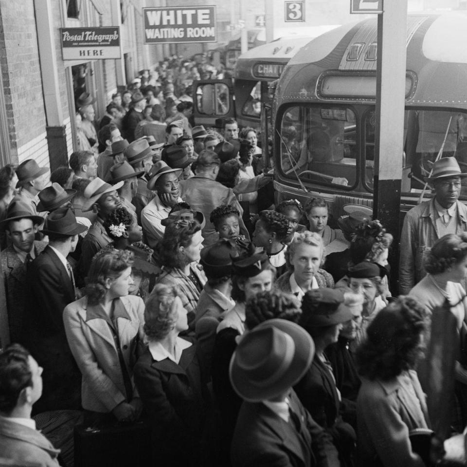  Passengers crowd the pavement as they wait for their coach to arrive