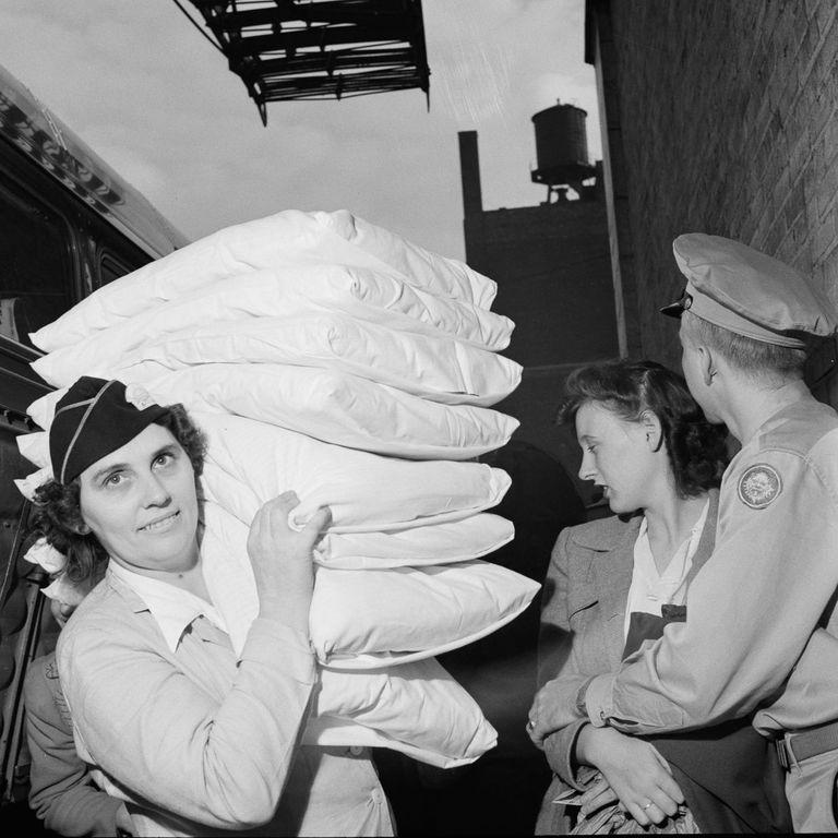  A member of staff brings the pillows for night coach passengers through the station