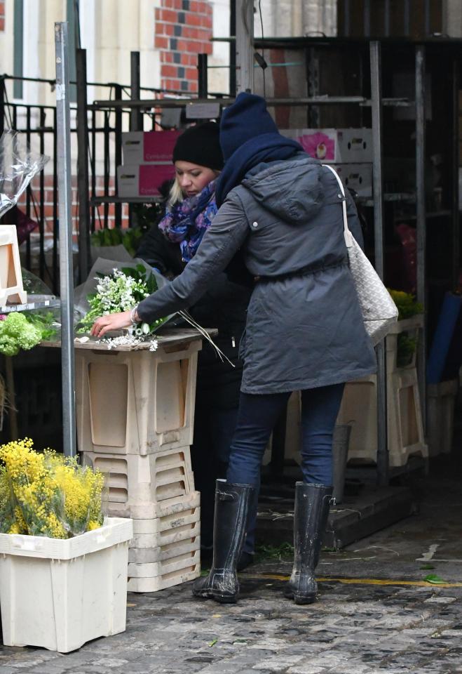  The brunette beauty spoke to the florist as she bought several bunches of flowers