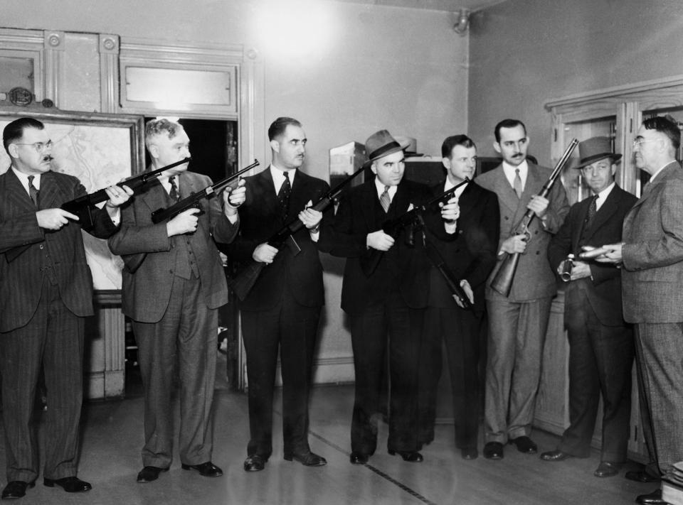  Police officers hold their weapons during a press conference in Washington where they warned mobsters to stay out of the city