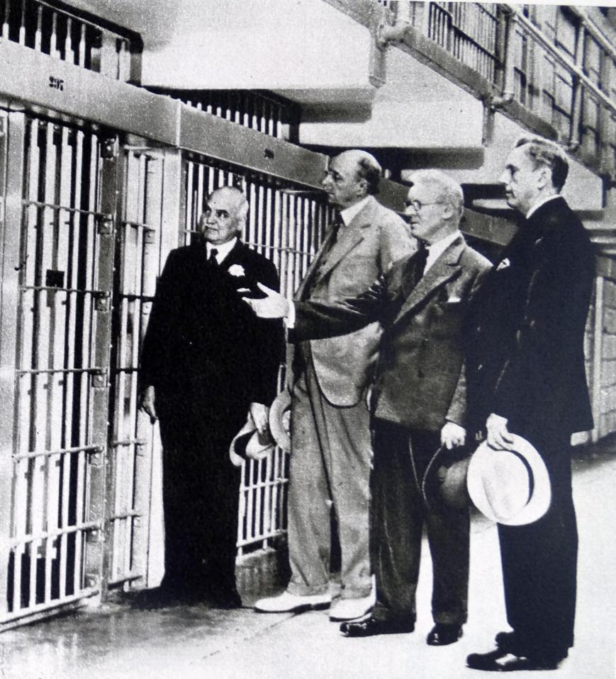  Police officers inspect the jail cell of Al Capone after he was jailed during the 1930s for tax evasion