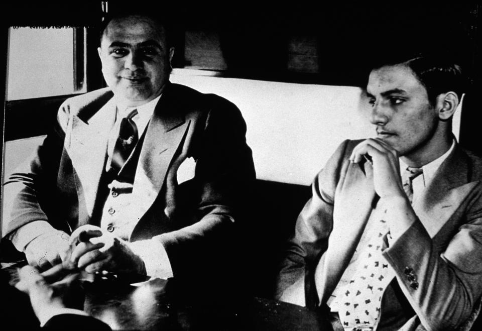  Al Capone sits in a train carriage with one of his associates as he is transferred to prison in 1931