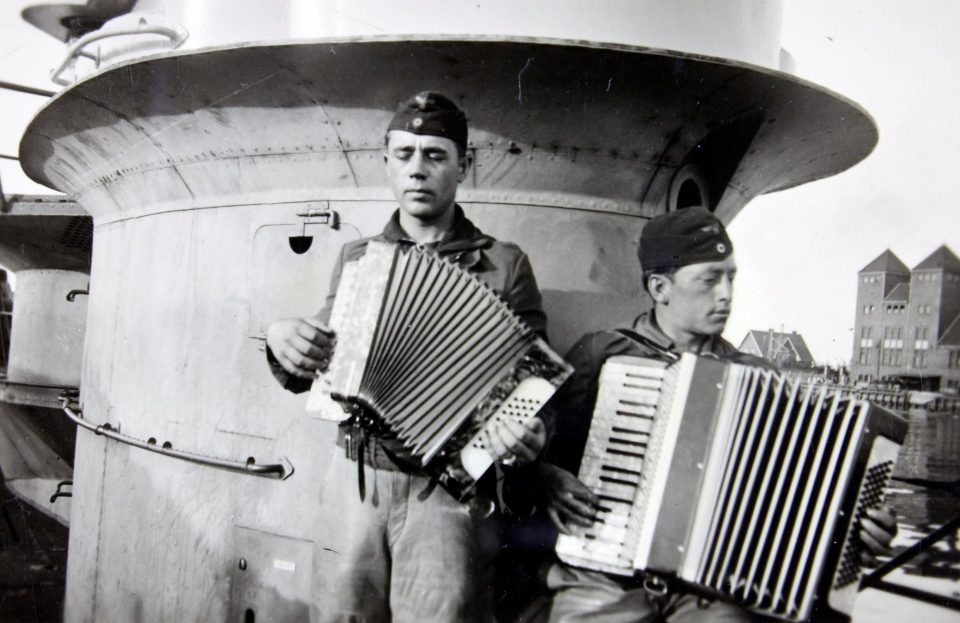  Pair enjoy a break by playing accordions on deck of U-boat