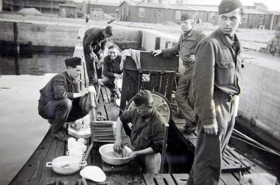  Crew members scrub pots and pans as U-boat sits in dock