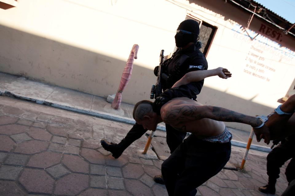  Armed cops cover their faces with balaclavas to avoid the risk of reprisals from the bloodthirsty gangs