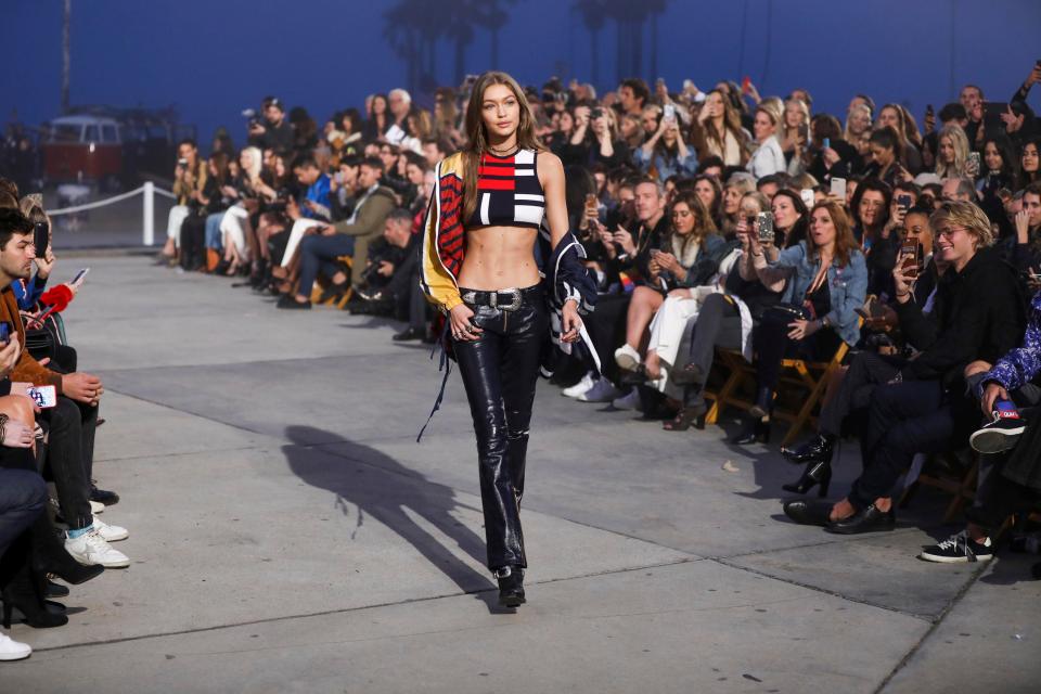  Gigi showed off her toned abs in a cropped top and patent trousers for her first look