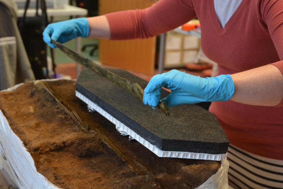  Archaelogists work on a Bronze Age Hoard in their lab after a gold-decorated bronze spearhead was discovered on a site in Scotland