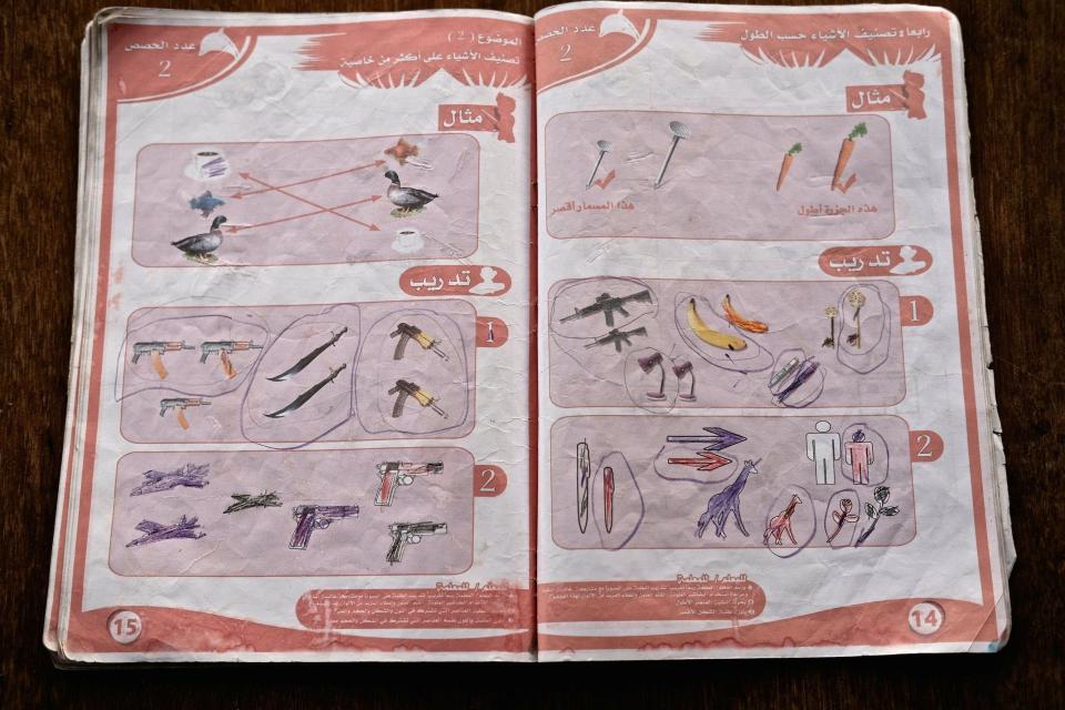  A tatty textbook shows different types of firearm that appear to have been circled by a young student